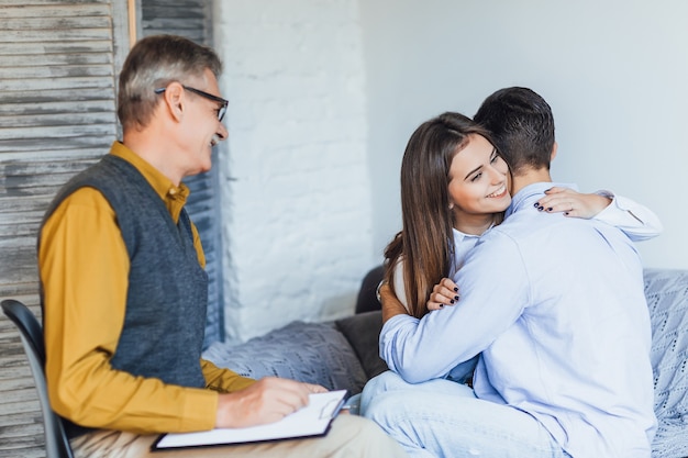 Foto gratuita cople casado feliz en la oficina del psicólogo con emociones sinceras