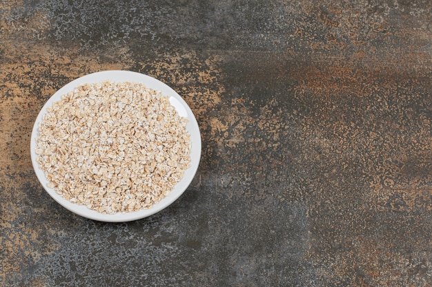 Copos de avena sabrosos en un plato blanco.