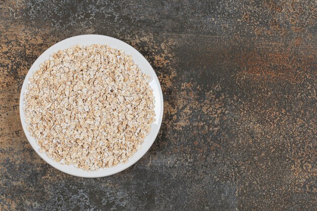 Copos de avena sabrosos en un plato blanco.