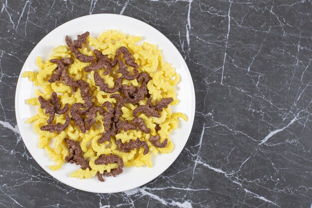 Copos de cereales esparcidos en un plato blanco.