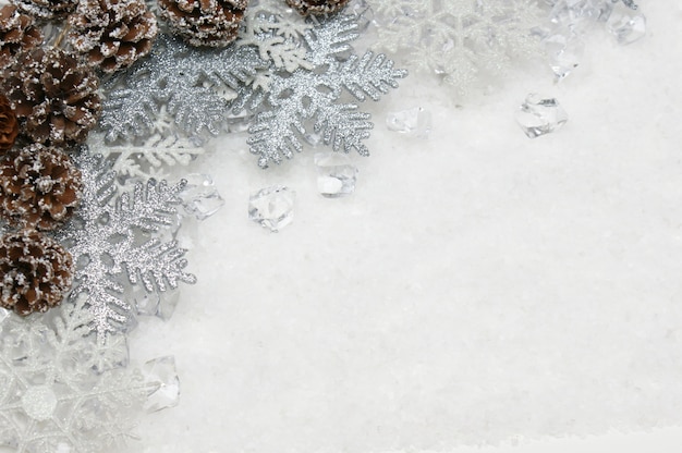 Copos de nieve de Navidad de plata y piñas enclavadas en el hielo