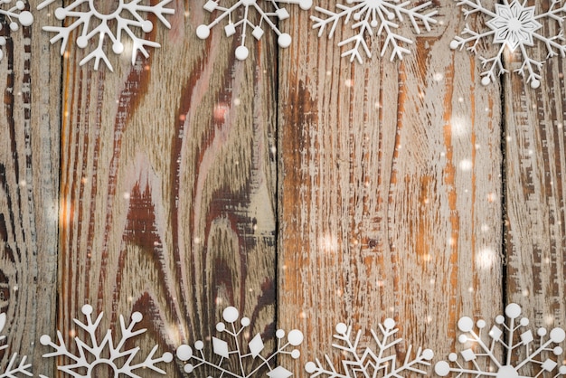 Copos de nieve de papel en el fondo de madera
