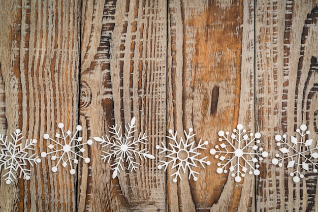 Copos de nieve de papel en el fondo de madera