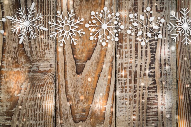 Copos de nieve de papel en el fondo de madera