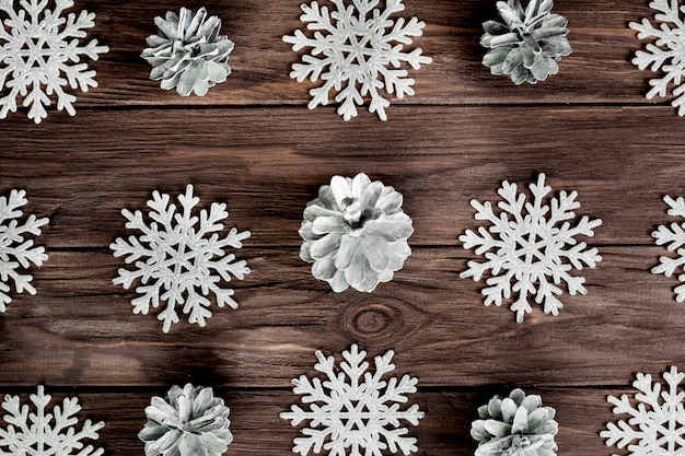 Copos de nieve de papel y ligeros enganches en tablero de madera