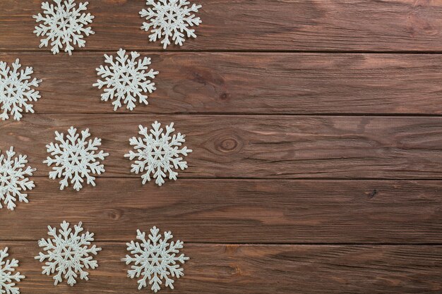 Copos de nieve de papel sobre tabla de madera
