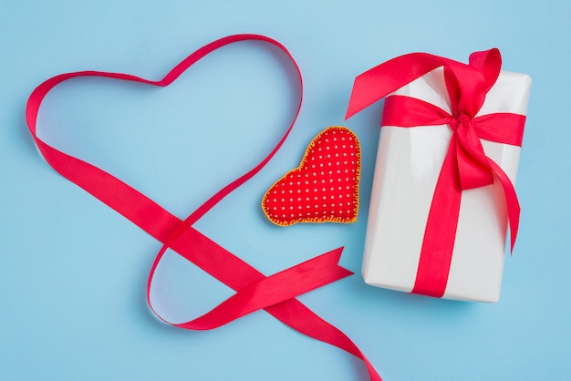Corazón y cinta cerca de regalo