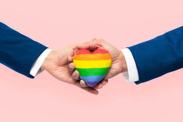 Foto gratuita corazón comunitario lgbtq + con manos unidas