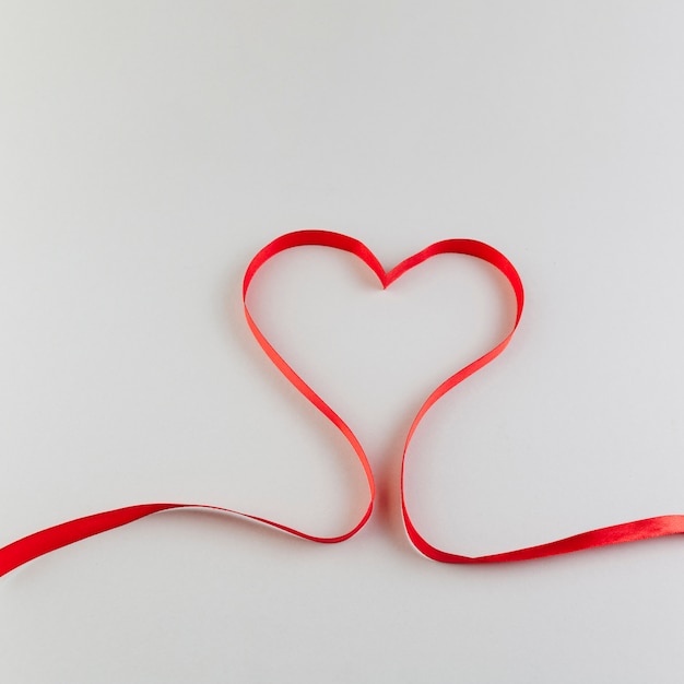 Corazón hecho de cinta de raso rojo.