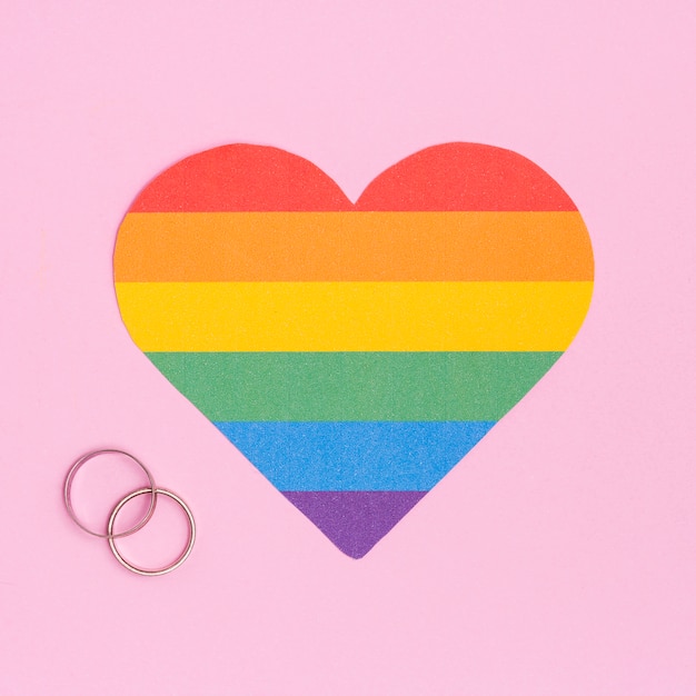 Corazón multicolor de LGBT y anillos de boda.