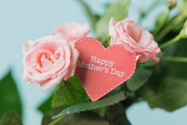 Corazón de papel entre dos flores para el día de la madre