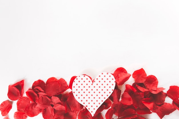 Corazón de papel en pétalos de flores