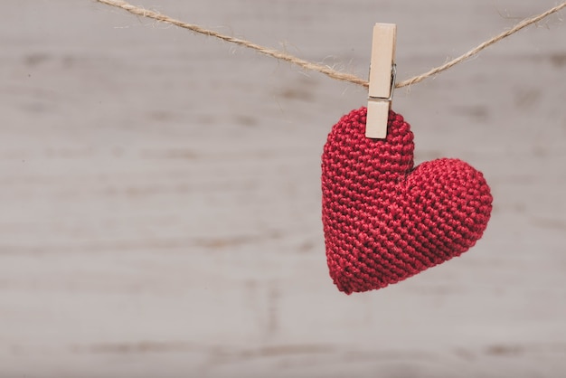 Corazón de peluche rojo colgando de una cuerda