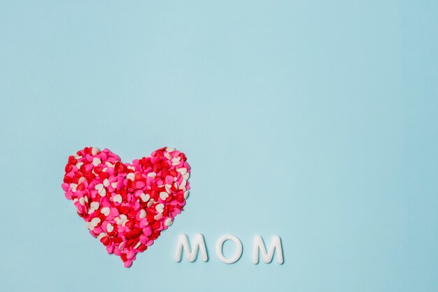 Corazón de pequeñas decoraciones cerca de la palabra mamá