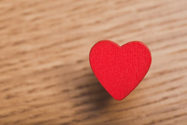 Corazón rojo de cerca en una mesa de madera