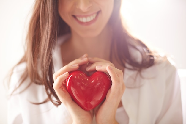 Corazón rojo en manos de una mujer