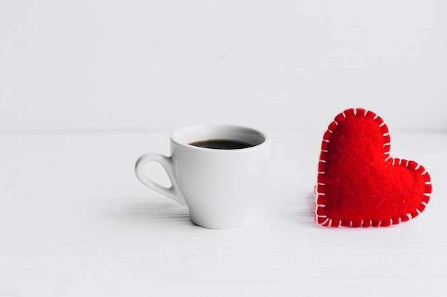 Foto gratuita corazón de tela y taza de café