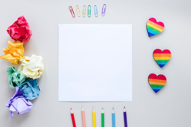 Foto gratuita corazones de arcoiris con papel y lapices.