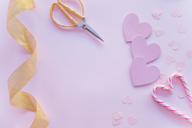 Corazones de papel con bastones de caramelo en la mesa