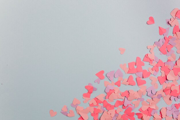 Corazones de papel dispersos en diagonal.