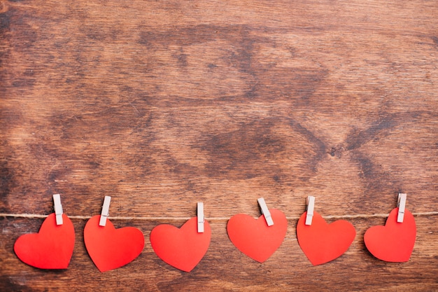 Foto gratuita corazones de papel pequeños sujetos a cuerda.