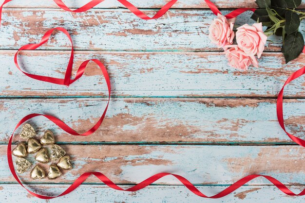 Corazones pequeños con rosas en la mesa.