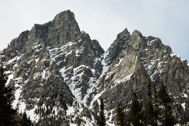 Cordillera de montañas rocosas cubiertas de nieve bajo el cielo brillante
