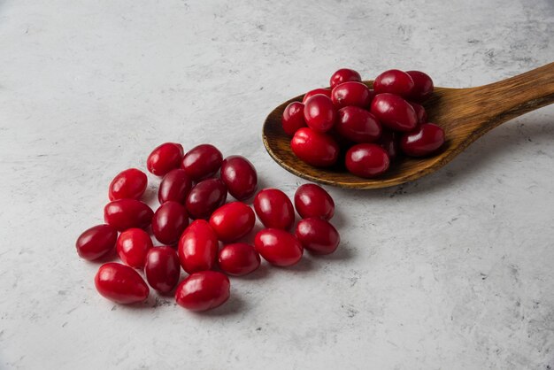 Corneles rojos en una cuchara de madera.