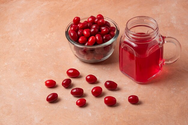 Corneles rojos en vaso con jugo en el frasco.