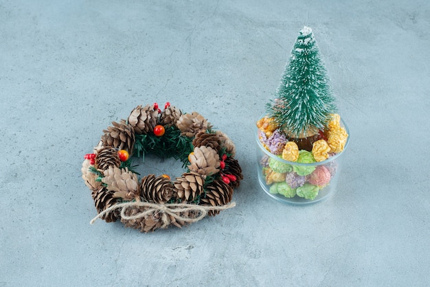 Una corona de Navidad con árbol y palomitas de maíz de colores.