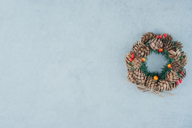 Una corona de Navidad de piña sobre fondo de mármol. Foto de alta calidad