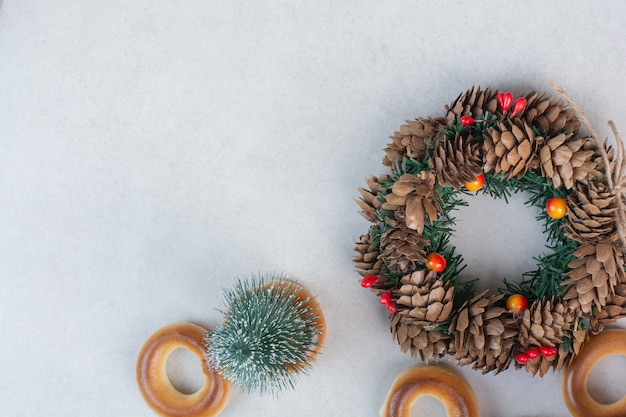Corona de Navidad de piñas con galletas sobre fondo blanco Foto de alta calidad