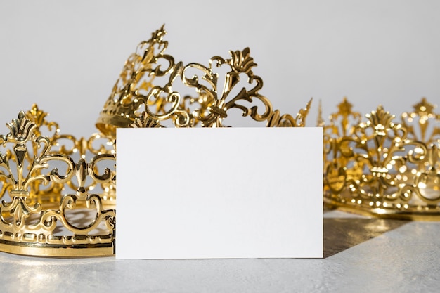 Foto gratuita coronas de oro del día de la epifanía con tarjeta en blanco