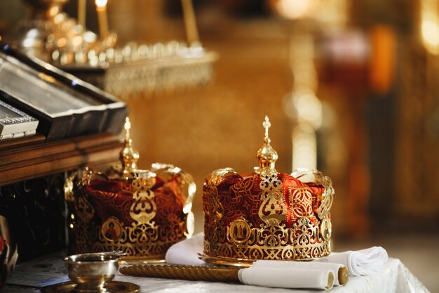 Coronas rituales sagradas del matrimonio en la iglesia de la catedral y las velas rituales