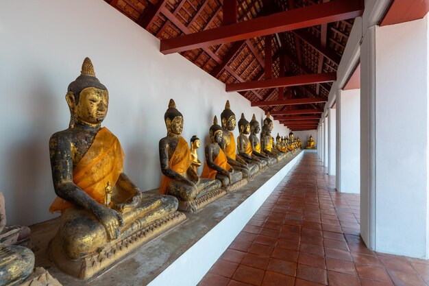Corredor con estatuas de Buda en Wat Phra Borommathat Chaiya Worawihan Surat Thani