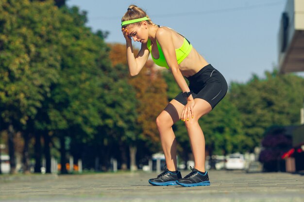 Corredor femenino, atleta entrenando al aire libre en el día soleado de verano.