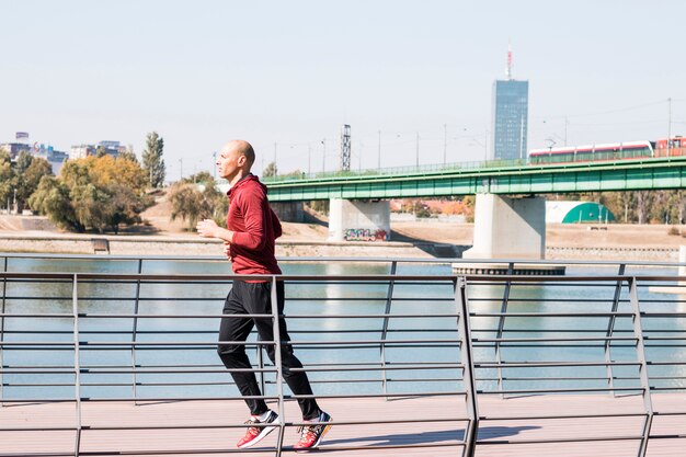 Corredor hombre caucásico corriendo cerca del río