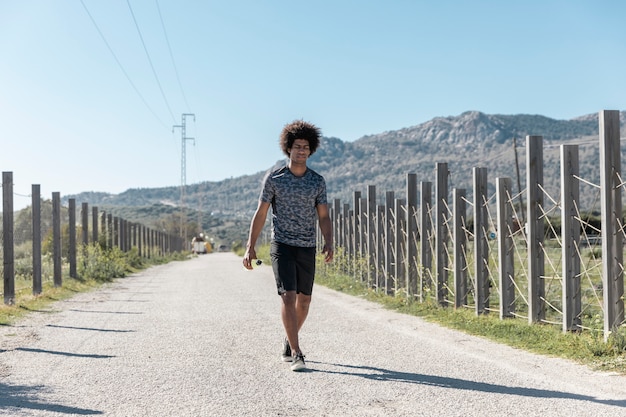 Corredor joven cansado caminando por la carretera vacía