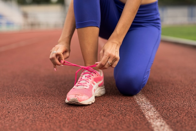 Foto gratuita corredor mujer ata cordones de zapatos