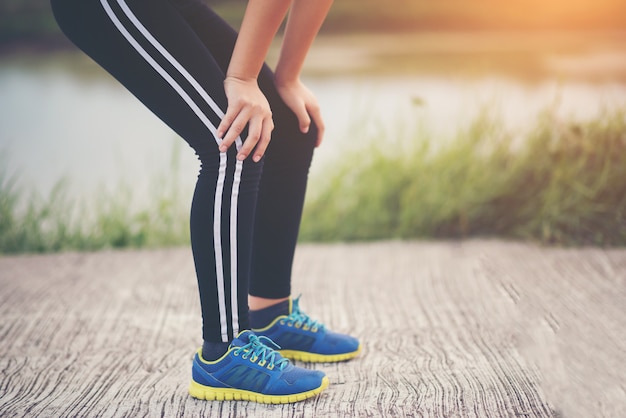 Corredor de mujer de fitness cansado tomando un descanso después de correr rápido