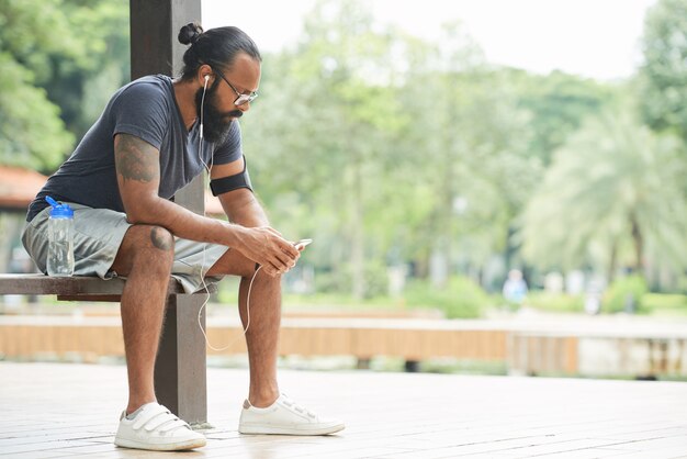 Corredor con smartphone al aire libre