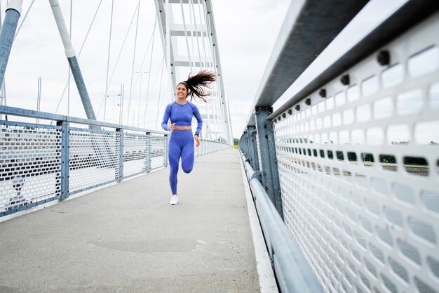 Corredoras con cuerpo fuerte y piernas corriendo por el puente y entrenamiento