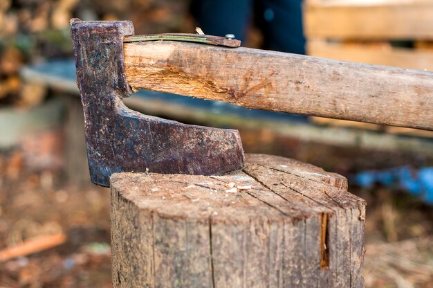 Cortando madera con hacha. Hacha atorada en un tronco de madera