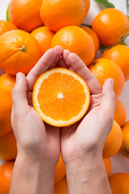 Cortar parte de fruta naranja en manos humanas