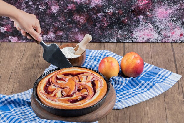 Cortar una rebanada de pastel de chocolate sobre una tabla de madera