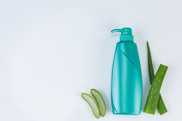 El corte fresco del áloe vera se va en la pared blanca. El uso de aceite esencial de aloe vera a partir del uso de material natural en belleza.