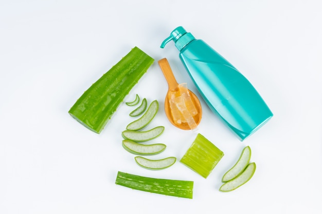 El corte fresco del áloe vera se va en la pared blanca. El uso de aceite esencial de aloe vera a partir del uso de material natural en belleza.