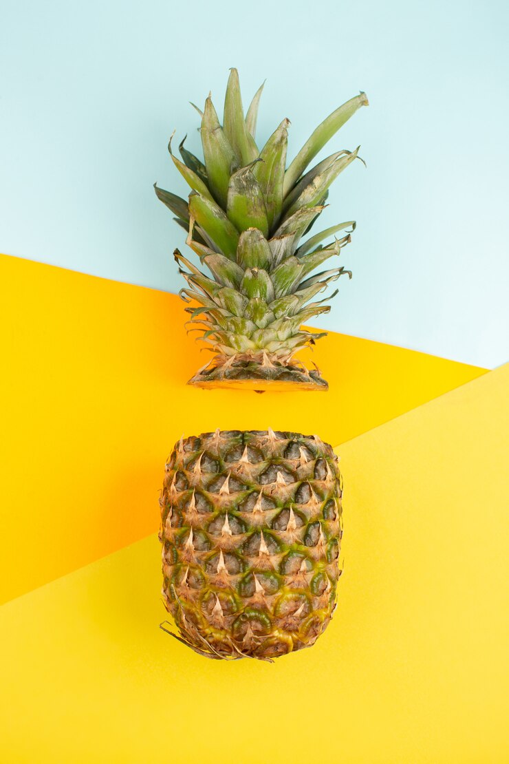 Corte la piña suave y jugosa en el escritorio azul hielo y amarillo