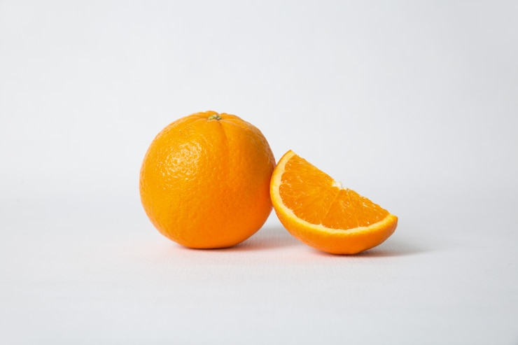Foto gratuito corte la sección de naranja y la fruta entera.