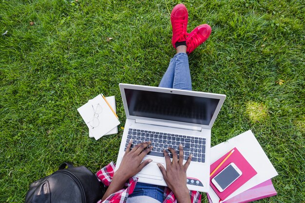 Cosecha de mujer que trabaja con la computadora portátil